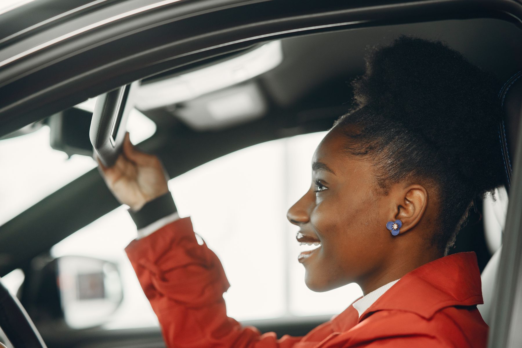 Smiling young woman at the wheel of a car